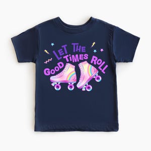 A navy blue t-shirt with a graphic design featuring two roller skates and the text "Let the good times roll" in a colorful, playful style.
