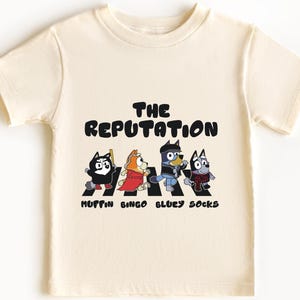The Reputation Muffin T-Shirt – Funny Socks & Bingo Cartoon Tee, Blue Dog Character Shirt, Comfortable Unisex Tee