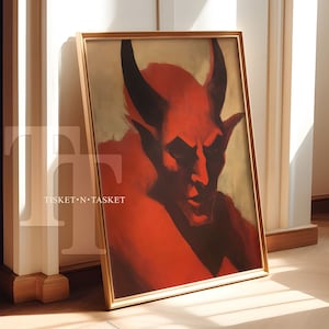 Puede incluir: Una pintura enmarcada de un diablo rojo con cuernos y una expresión seria. La pintura está sobre un fondo amarillo claro.