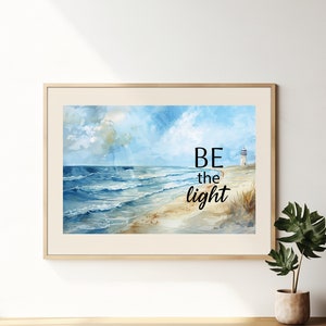 May include: A watercolor painting of a lighthouse on a beach with waves crashing on the shore. The sky is blue with white clouds. The text "BE the light" is written in black on the beach.