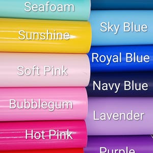 May include: A collection of vinyl rolls arranged in two columns, featuring colors labeled Light Aqua, Seafoam, Sunshine, Soft Pink, Bubblegum, Hot Pink, Red, Dark Aqua, Sky Blue, Royal Blue, Navy Blue, Lavender, and Purple.