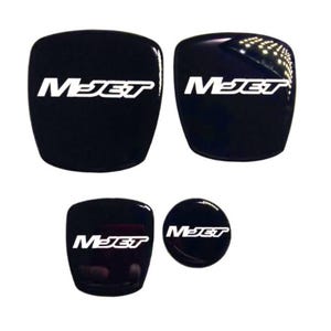 Op de afbeelding: Vier zwarte en witte M-Jet logo stickers. De stickers zijn in verschillende maten en vormen. De grootste sticker is een vierkant, de op een na grootste is een cirkel en de twee kleinste zijn ovalen.