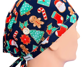 May include: A blue scrub hat with a Christmas-themed print featuring gingerbread men, candy canes, Christmas trees, and Santa Claus. The hat has a button on the top and ties at the back.