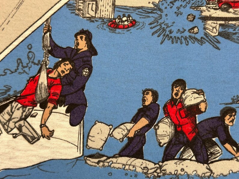 May include: A comic-style illustration depicts a flood rescue scene. A person in a red shirt is being pulled from the water by a rescuer in a blue uniform. Other figures are shown carrying sandbags. The background shows flooded buildings and a rescue boat.