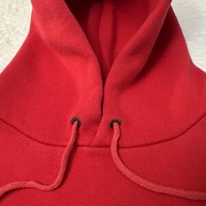 Puede incluir: Sudadera con capucha roja con cord&oacute;n y ojales negros.