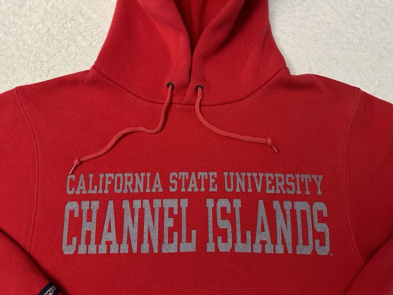 Puede incluir: Sudadera roja con capucha con el texto "CALIFORNIA STATE UNIVERSITY CHANNEL ISLANDS" en letras grises.