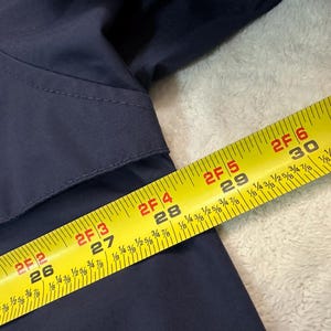 May include: A handmade wooden sign with the word "Welcome" in a whimsical font. The sign is painted white with a distressed finish, and features a floral design in pinks and greens. It measures approximately 30 cm wide.