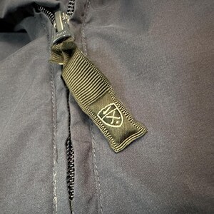 May include: A white ceramic mug with a black handle and the text "But First, Coffee" in a bold, black font. The mug is on a white surface.