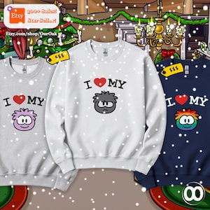 May include: Three crewneck sweatshirts in light gray, white, and navy blue. Each features the text I heart MY above a cartoon character graphic. The light gray sweatshirt has a light purple character, the white has a gray one, and the navy has a rainbow one.