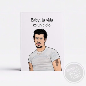 May include: A white greeting card featuring an illustration of a man with dark curly hair, a goatee, and a gold chain. The text "Baby, la vida es un ciclo" is above the illustration. The card has a circular logo that says "DESIGNED BY WILDEST CLOSET".
