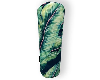May include: A green and black golf club head cover with a tropical leaf pattern.