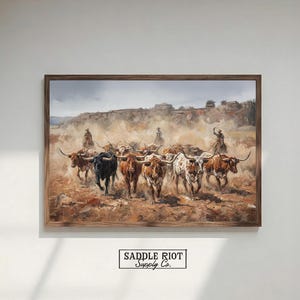 The image is a framed painting depicting a group of cattle in a field, with a cowboy on horseback leading the herd.