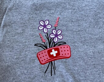 Camiseta de auxiliar de enfermería con estampado de vendaje y flores, regalo de ropa médica