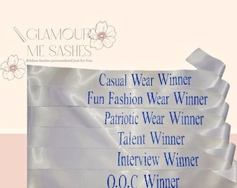 May include: White satin sashes with blue text. The sashes read: "Casual Wear Winner", "Fun Fashion Wear Winner", "Patriotic Wear Winner", "Talent Winner", "Interview Winner", and "0.0.C Winner".