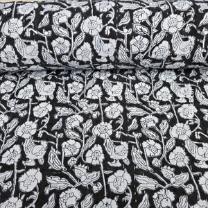 May include: Black fabric with a white floral pattern. The fabric is printed with a repeating design of flowers and leaves.