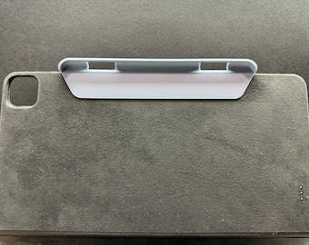 May include: A gray felt iPad case with a gray plastic stand attached to the top. The stand has three slots for holding the iPad at different angles.
