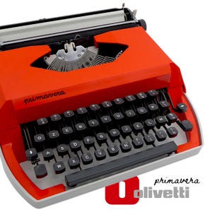 Peut inclure: Une machine à écrire Olivetti Primavera vintage de couleur orange vif. La machine à écrire est dotée d'un clavier noir avec des lettres blanches, et le mot "primavera" est imprimé sur le dessus. Le design est de style rétro.