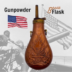 Puede incluir: Una petaca de latón de color cobre con las palabras "Gunpowder" y "Brass Flask" en la imagen. La petaca tiene un diseño en relieve detallado con cañones, banderas y armas. También se ve una bandera estadounidense.