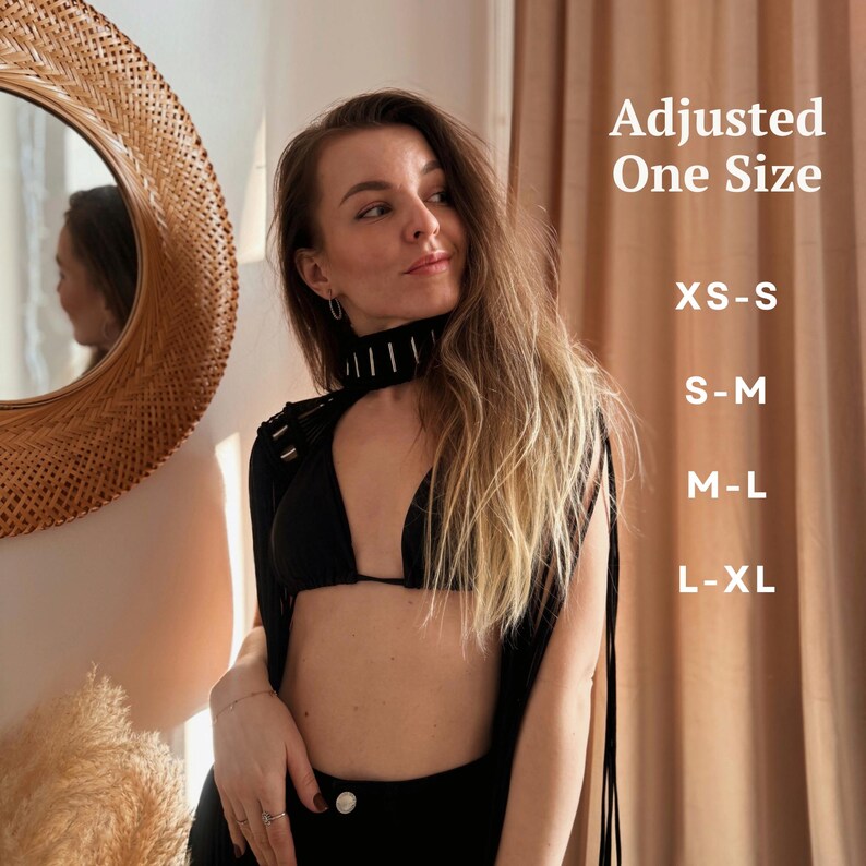 Peut inclure: Une femme portant un haut noir &agrave; franges avec un haut de bikini noir en dessous. Le haut a un d&eacute;tail de cha&icirc;ne argent&eacute;e autour du cou. Le texte "Adjusted One Size" et "XS-S, S-M, M-L, L-XL" est visible sur le c&ocirc;t&eacute; droit de l'image.