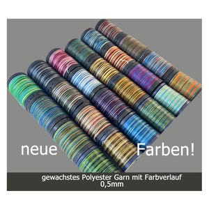 Peut inclure: Une collection de bobines de fil polyester ciré avec des dégradés de couleurs. Le fil mesure 0,5 mm d'épaisseur. Les bobines sont disposées en demi-cercle avec le texte "neue Farben!" et "gewachstes Polyester Garn mit Farbverlauf 0,5mm" en dessous.