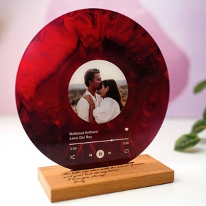 May include: A personalised record stand in red and white with a photo of a couple and a music player interface. The text on the stand reads "The hills are alive with the sound of music and you have a home in my heart. I love you always.  "