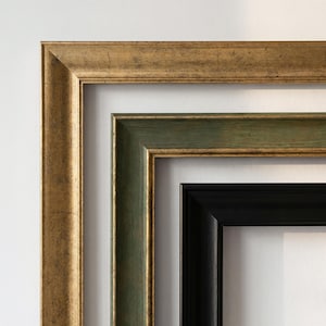 K&ouml;nnte beinhalten: Drei ineinander verschachtelte rechteckige Bilderrahmen in Eckanordnung. Der &auml;u&szlig;erste Rahmen ist goldfarben mit strukturierter Oberfl&auml;che, der mittlere Rahmen ist salbeigr&uuml;n mit goldenen Kanten und der innerste Rahmen ist schlicht mattschwarz.