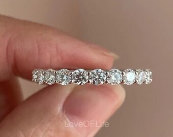 May include: A silver band with a row of round, clear gemstones.