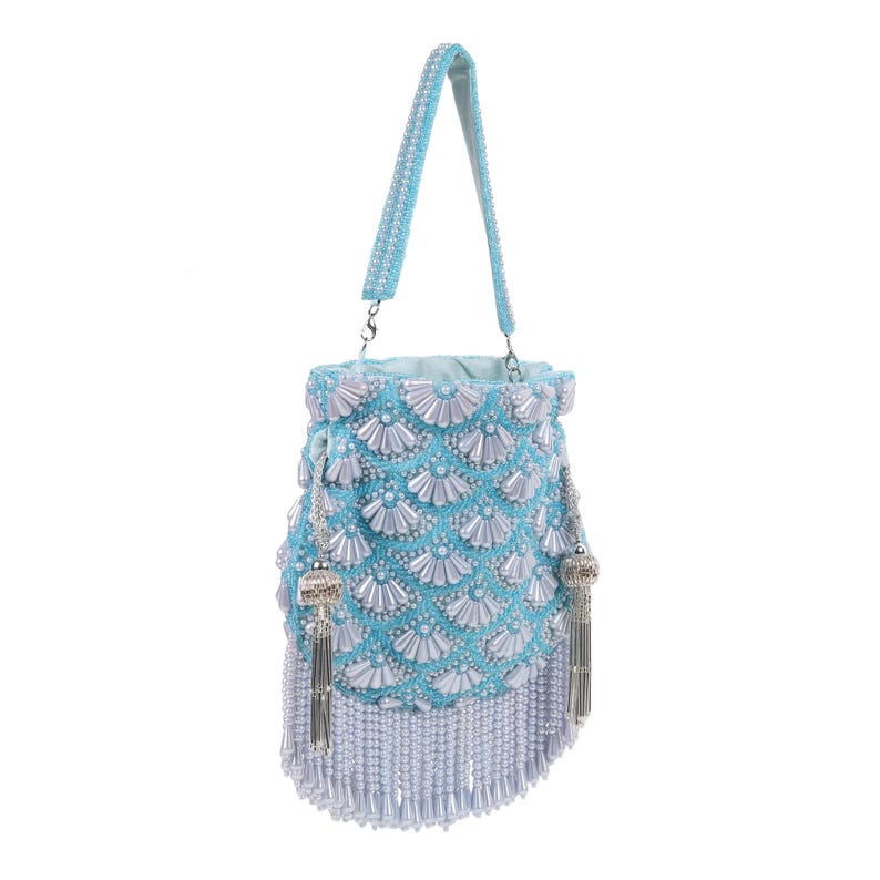 May include: A light blue beaded handbag with a matching handle. The bag is adorned with white pearl-like beads in a scalloped pattern. Silver tassels hang from the sides and bottom, adding a touch of elegance. The bag is approximately 8 inches tall.