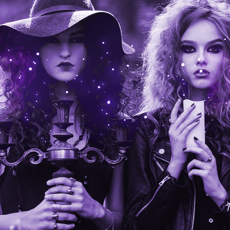 May include: A dark-haired individual wearing a wide-brimmed hat holds a metal candelabra, while another individual with curly hair holds a white pillar candle. Both are dressed in black, with purple lighting and floating light particles.