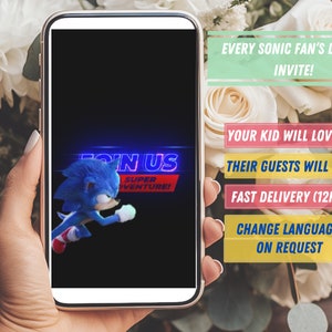 May include: A smartphone displaying a Sonic the Hedgehog movie poster with the text "Join Us Super Adventure!" The poster features a blue hedgehog running. The phone is held in a hand. The background is a bouquet of white roses.