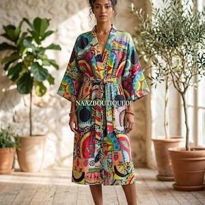 Könnte beinhalten: Ein farbenfroher Kimono-Stil-Bademantel mit Muster und Gürtel. Der Bademantel hat eine Mischung aus roten, blauen, gelben und grünen Designs. Der Text "NAAZBOUTIQUE01" ist sichtbar. Der Bademantel ist knielang, ca. 100 cm.