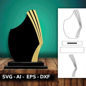 Puede incluir: Un trofeo negro y dorado con un diseño en capas. El trofeo tiene una base rectangular y una parte superior alta y curva. El trofeo está sobre una superficie de madera.