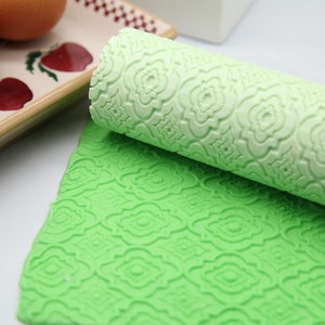 Peut inclure: Deux rouleaux à pâtisserie en silicone vert avec un motif en relief. Les rouleaux à pâtisserie sont utilisés pour décorer les gâteaux et les pâtisseries.