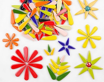 May include: Assortment of colourful ceramic flower shapes and teardrop-shaped tiles. The tiles are in various colours, including red, yellow, green, blue, and orange. The flower shapes are in various sizes and colours.
