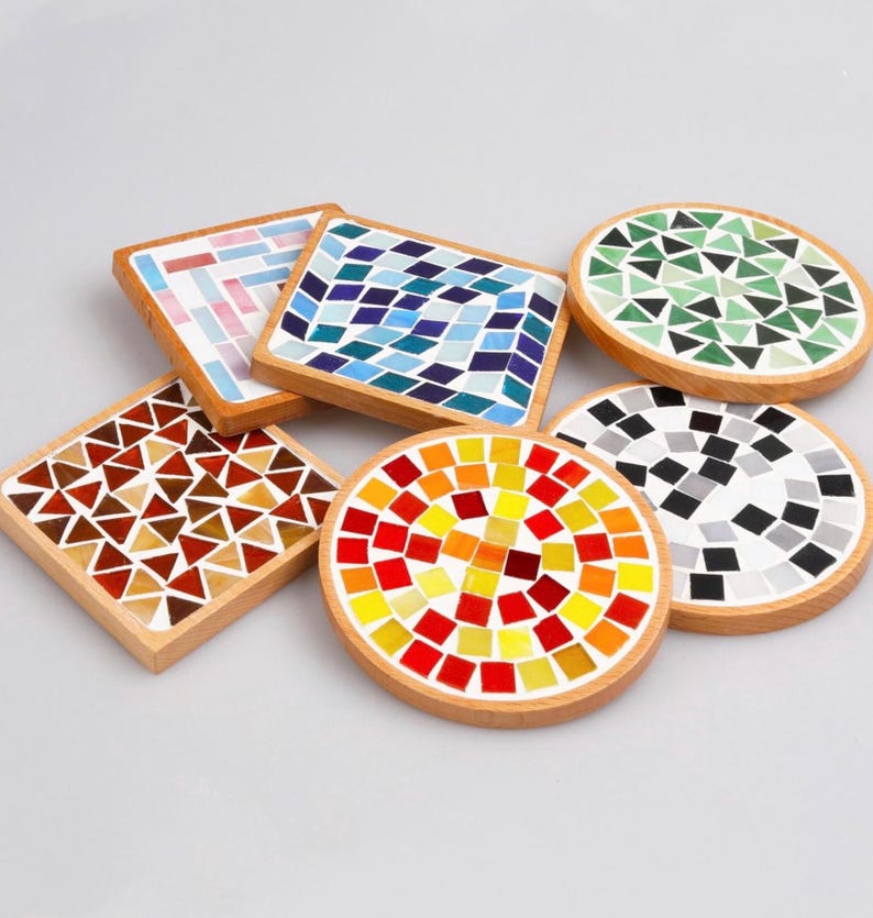 May include: Six colorful mosaic coasters with wooden bases. The coasters feature different geometric patterns in shades of blue, green, red, orange, yellow, and brown.