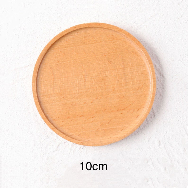 May include: A round, light brown wooden coaster with a diameter of 10 inches. The coaster is smooth and has a natural wood grain.