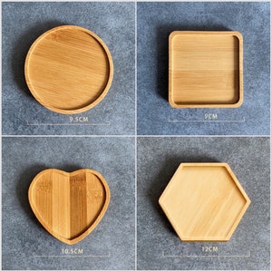 May include: Four wooden coasters in different shapes and sizes. The coasters are made of natural bamboo and are perfect for protecting surfaces from scratches and spills. The coasters measure 9.5 cm, 9 cm, 10.5 cm, and 12 cm in diameter.