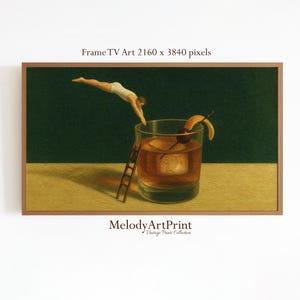 May include: A framed art print shows a person diving into a cocktail glass. The glass contains a large ice cube and a garnish. A small wooden ladder leans against the glass. The background is a dark green.