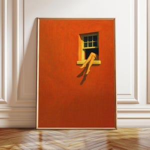 Puede incluir: Una impresión artística enmarcada que presenta una vibrante pared naranja con una ventana. La ventana muestra un par de piernas que se extienden hacia afuera. La obra de arte está colocada contra una pared blanca con molduras decorativas y un suelo de madera.