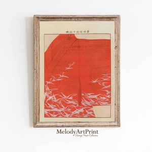 Puede incluir: Una impresión japonesa vintage en madera de un kimono rojo con pájaros blancos volando a su alrededor. La impresión está enmarcada en un marco de madera claro y tiene el texto "第三十四回" en la esquina superior derecha.