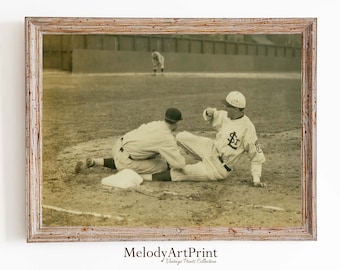 May include: A vintage black and white photograph of two baseball players on a field. One player is sliding into home plate while the other player is trying to tag him out.