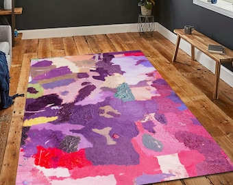Op de afbeelding: Een rechthoekig vloerkleed met een abstract ontwerp. Het vloerkleed heeft een levendige mix van kleuren, waaronder tinten roze, paars, rood en geel. Het ontwerp lijkt een geschilderd of getextureerd patroon te zijn, wat visuele interesse toevoegt aan de vloerbedekking.