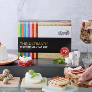 Peut inclure: Boîte du kit de fabrication de fromage ultime avec 40 variétés de fromages. Divers fromages sont présentés sur de petites assiettes et un verre à vin. Le kit comprend une variété de fromages, conçus pour les fromagers amateurs.