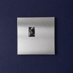 Square stainless steel picture frame hanging on wall