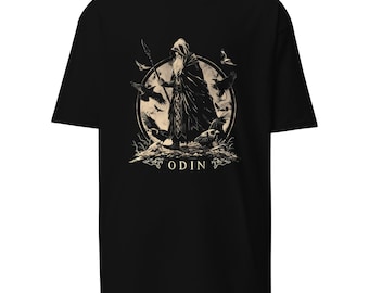 May include: Black t-shirt featuring a detailed illustration of Odin, a figure with a long beard and staff, surrounded by ravens. The design is in shades of beige and brown, with the word "ODIN" at the bottom.
