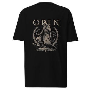 May include: Black t-shirt featuring a graphic print of Odin, a Norse god, holding a spear and surrounded by ravens. The text "ODIN" is printed above the graphic.