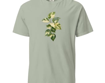May include: A sage green t-shirt with a white and green botanical illustration of a leafy plant.
