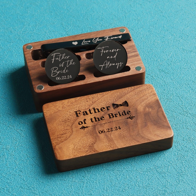 May include: Wooden box with a black cufflink set. The cufflinks are engraved with the text "Father of the Bride" and "Forever and Always". The box also has a tie bar engraved with the text "Love You Forever".