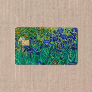 May include: A rectangular credit card featuring a printed reproduction of Vincent van Gogh's Irises painting. The design displays vibrant blue irises with green stems and leaves against a background of orange flowers and a gold chip.