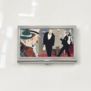 May include: A rectangular metal business card case featuring a colorful illustration of a cafe scene. The artwork depicts a woman in a green hat, a man in a top hat, and two waiters in black suits. The text "CAFE" and "RE" is visible in the background.